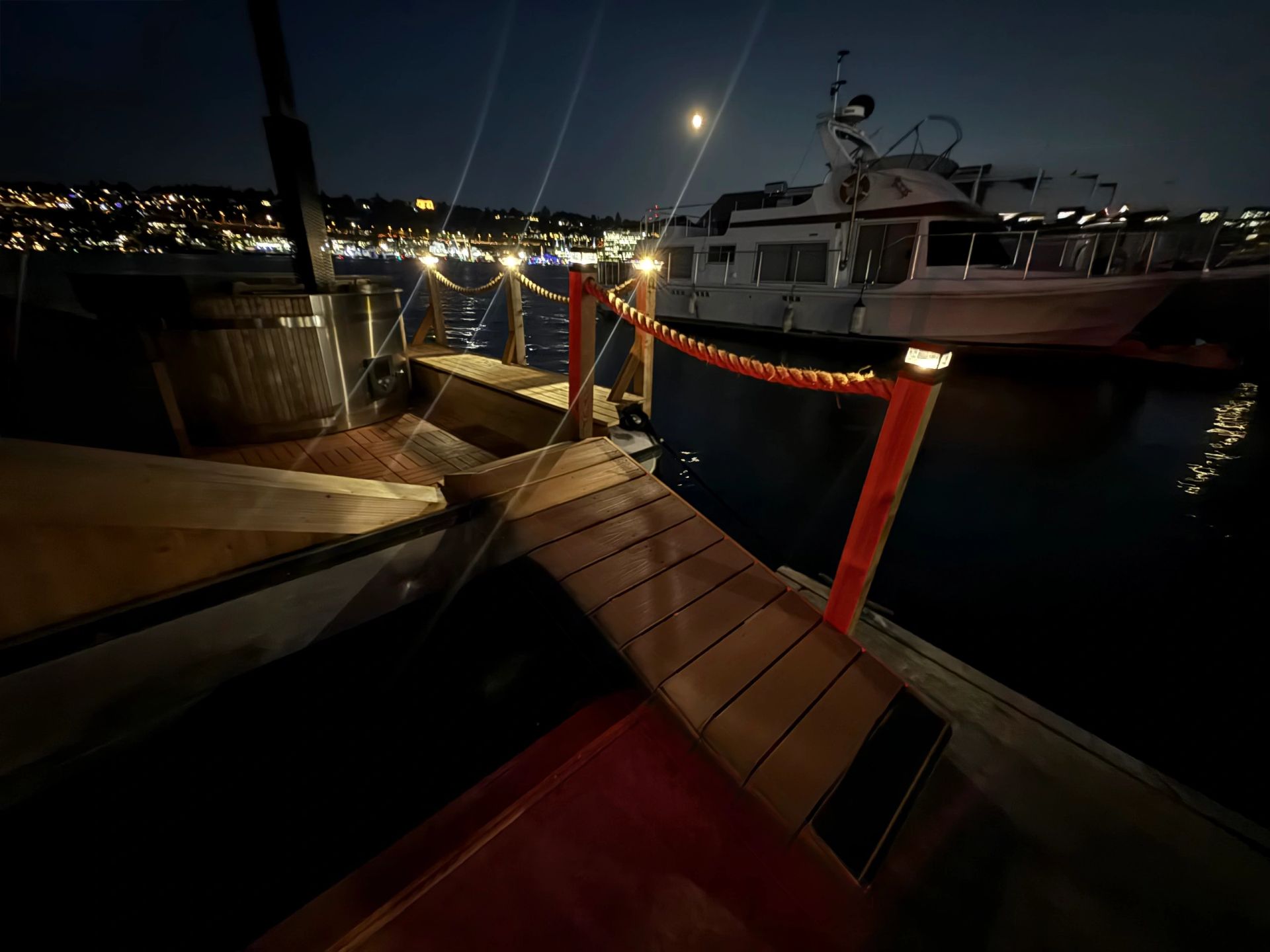 Banya Boat deck and hot tub under the lights at night on Lake Union